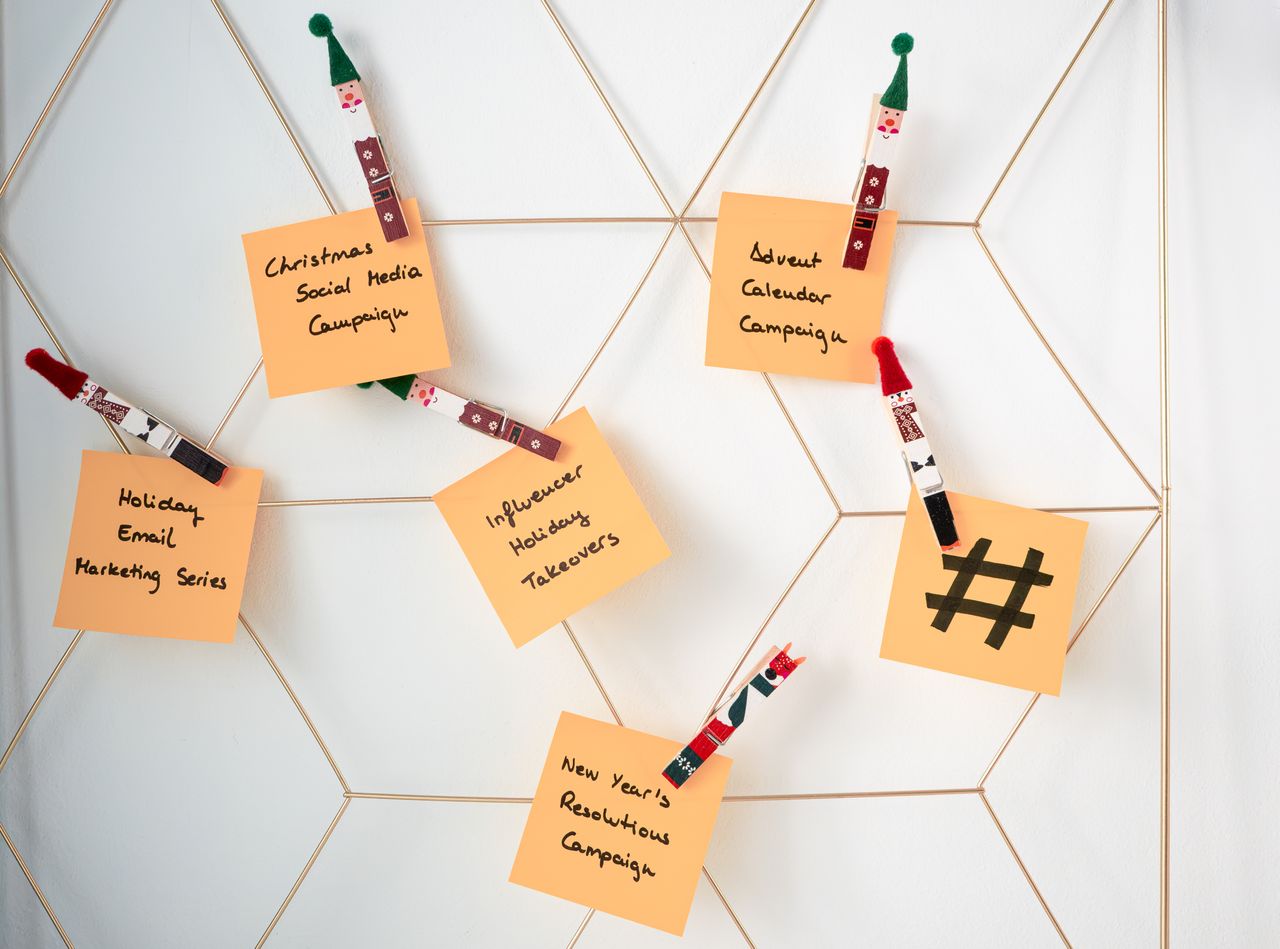 our-story Sticky notes with holiday marketing ideas clipped to a wall grid.